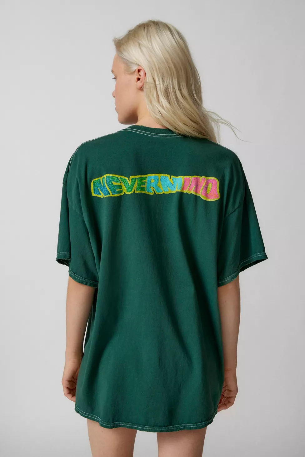 Woman wearing green T-shirt with colorful Nevermind text
