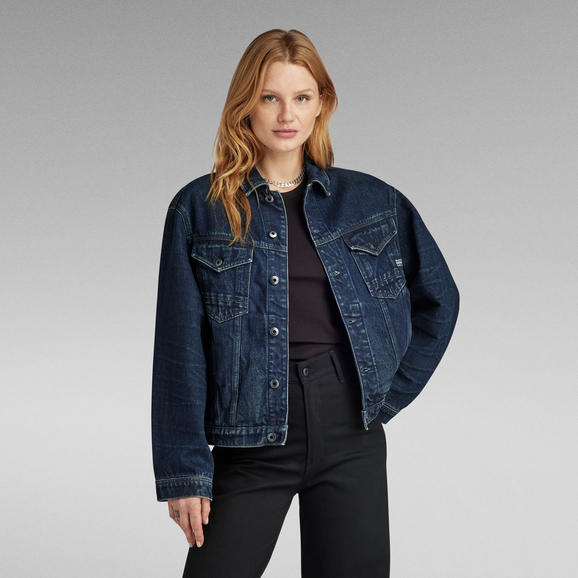Woman wearing dark denim jacket and black pants