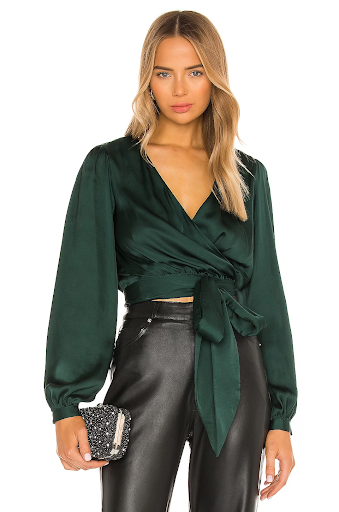 Woman in green wrap top and black pants