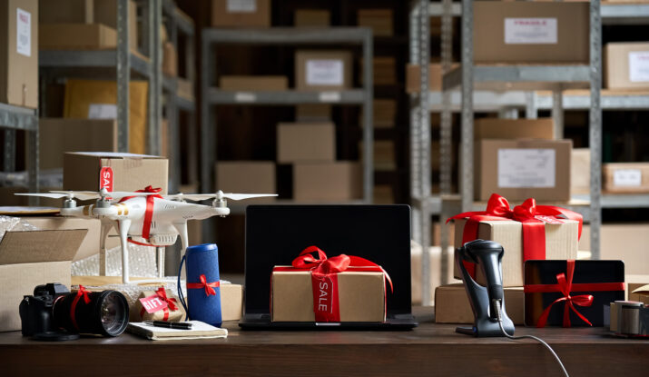 Warehouse table with gift-wrapped tech gadgets and boxes