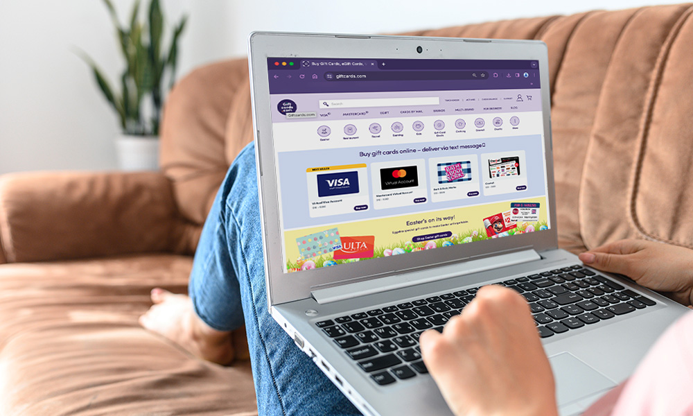 Person browsing gift card website on laptop at home