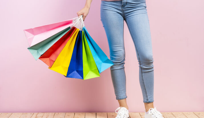 Person holding multiple colorful shopping bags