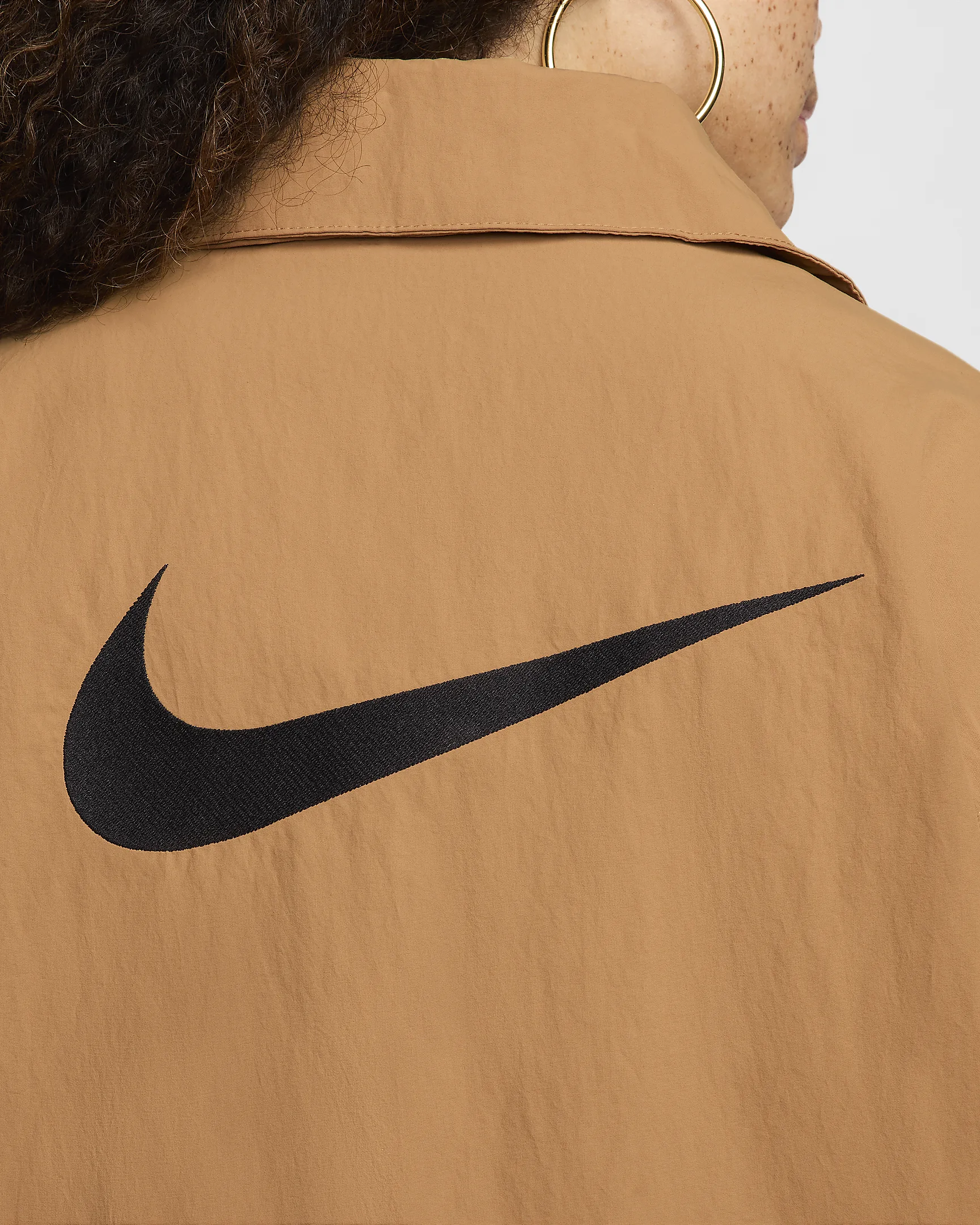 Black Nike logo on tan jacket back