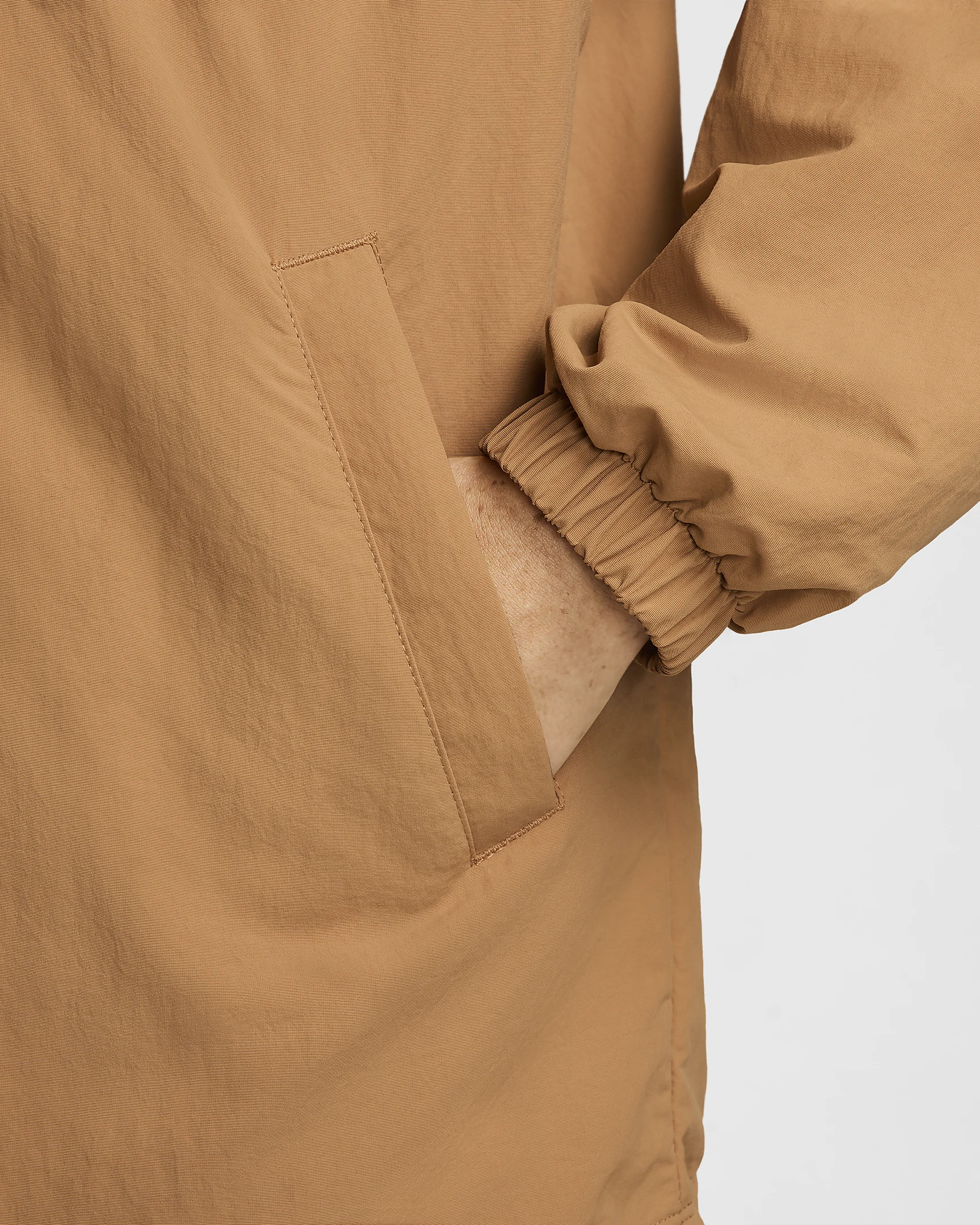 Hand inside camel jacket pocket with elastic cuff