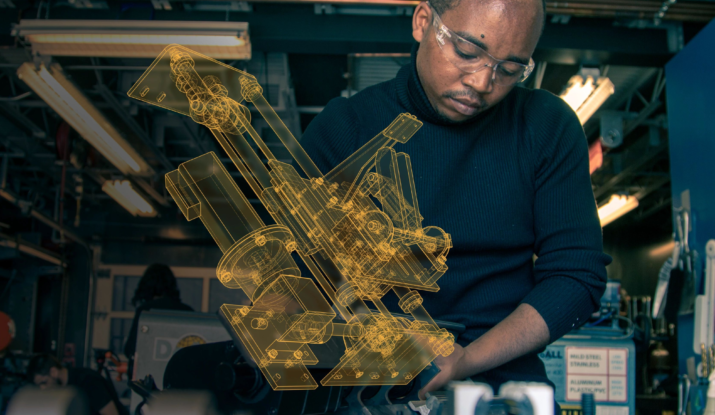 Engineer with safety glasses studying mechanical design model