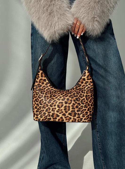 Leopard print handbag held with fur coat and jeans
