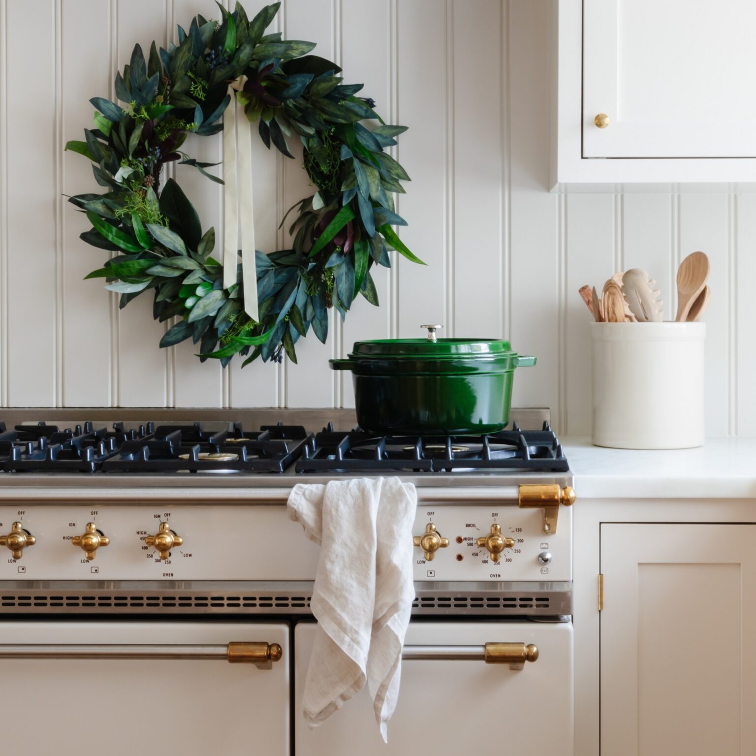 Green wreath above stove with green pot and utensils