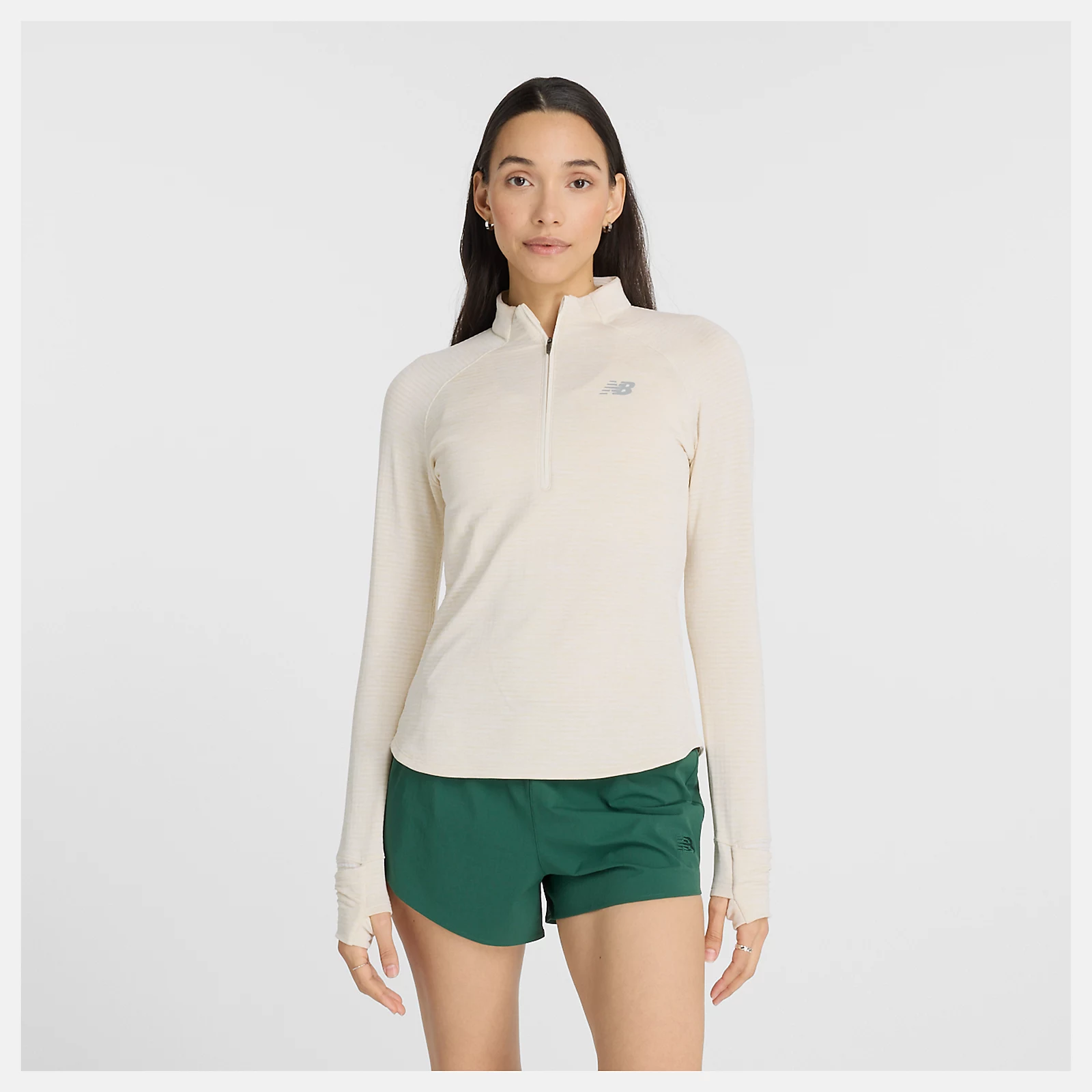 Woman wearing beige long-sleeve top and green shorts