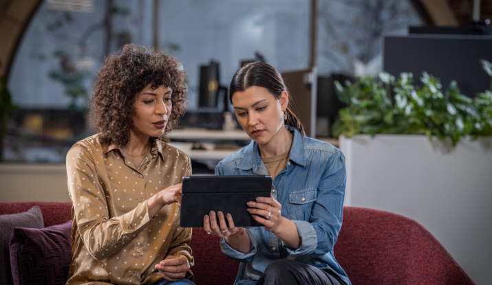 Two women looking at a tablet together indoors