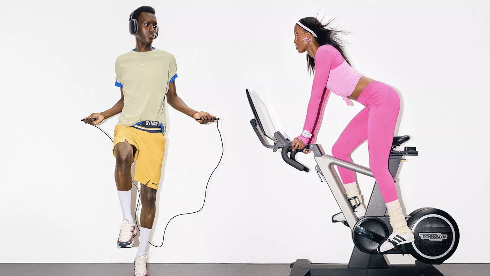 Man skipping rope and woman cycling indoors