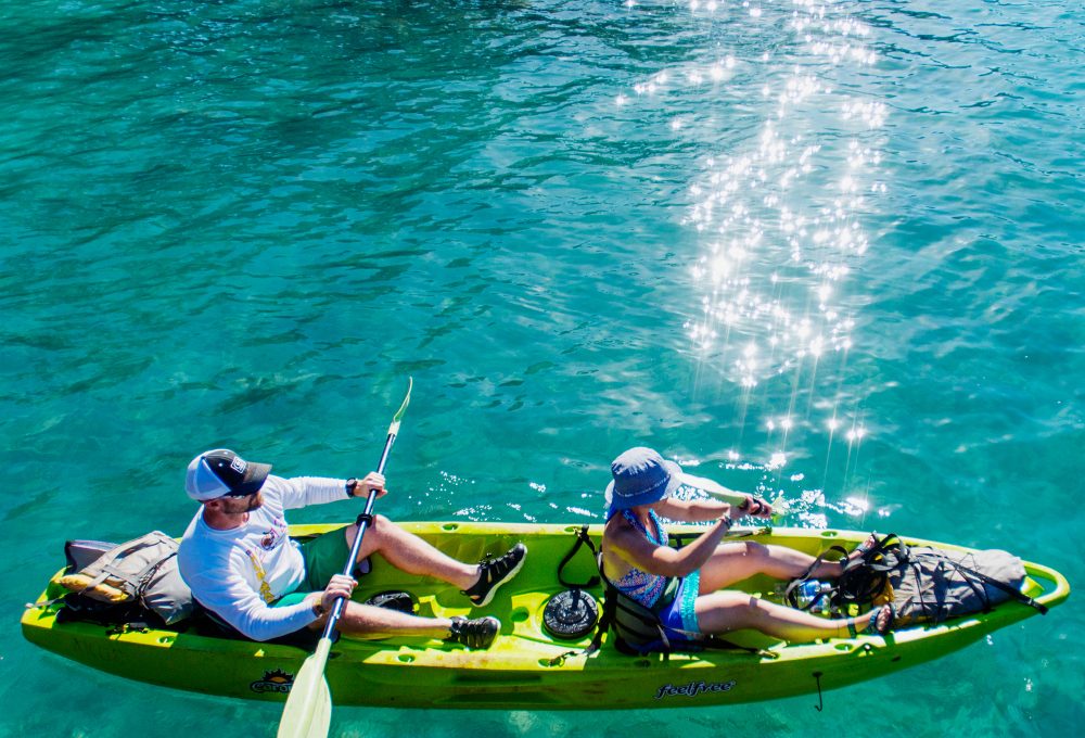 Two people kayaking on clear turquoise water