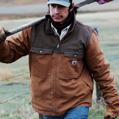 Man carrying shovel over shoulder in outdoor setting