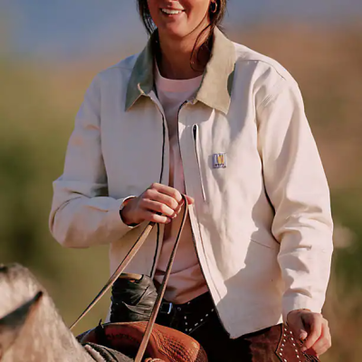 Person in beige jacket holding horse reins